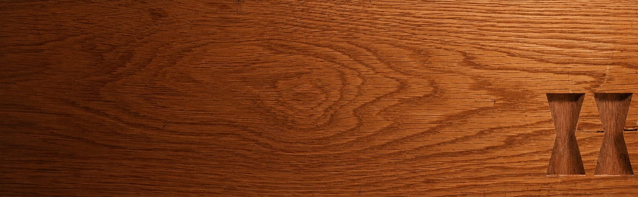 A white oak plank with two empty butterfly key mortises